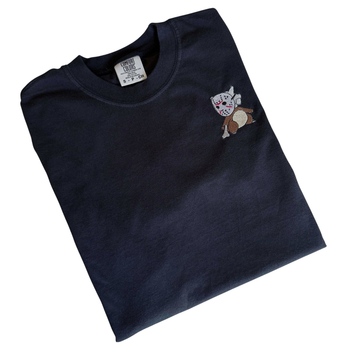 A folded dark navy blue t-shirt with a small embroidered cartoon bear graphic on the left chest, displayed on a clean white background.